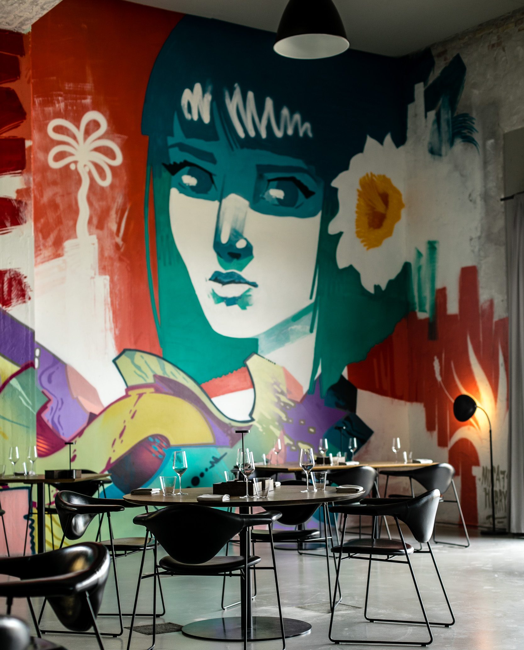 Portrait of Harry Bones painting a mural with aerosol color work